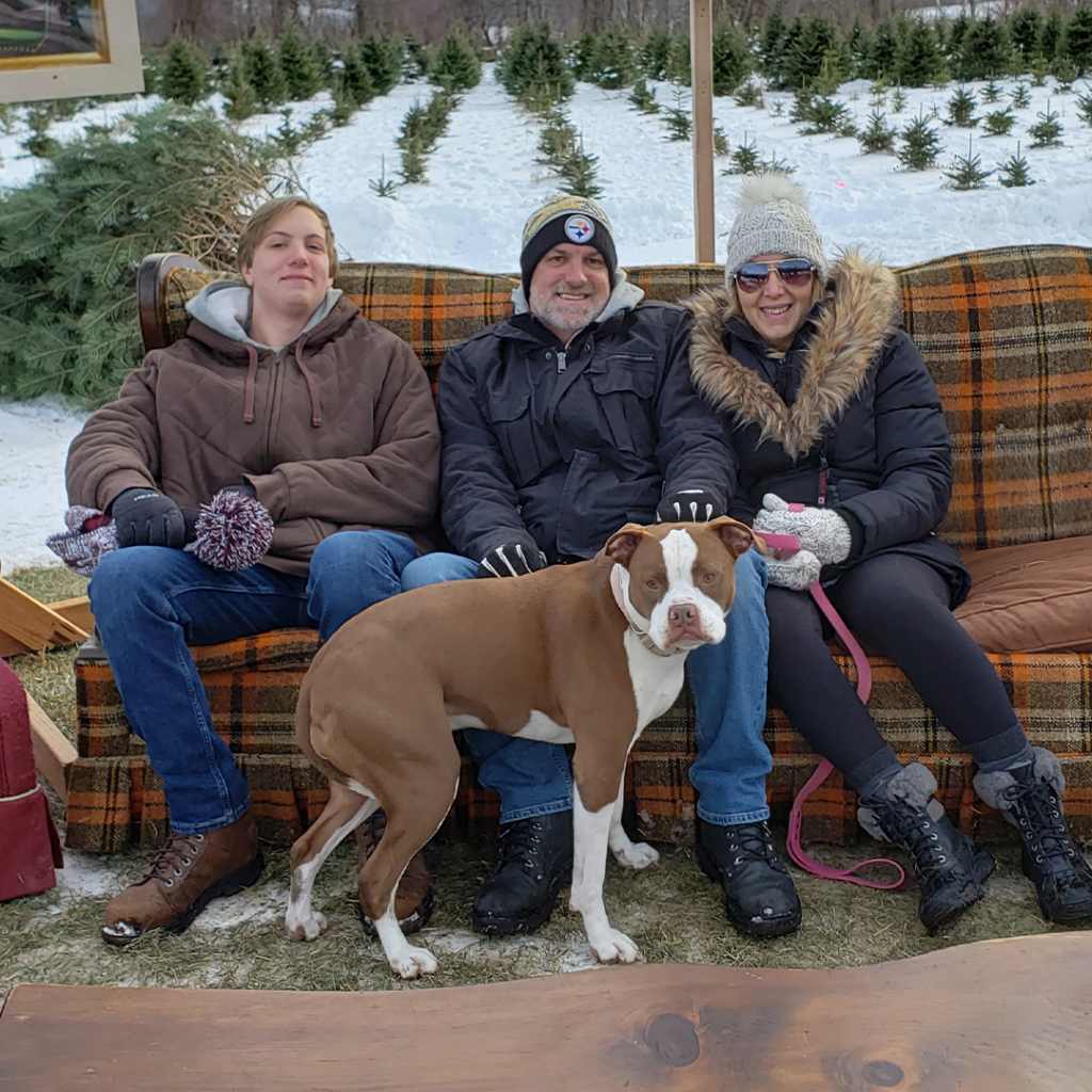 A family with their pit bull sitting on a couch
