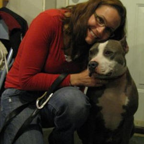Bruno, Therapy dog being hugged by a women in a red top and jeans